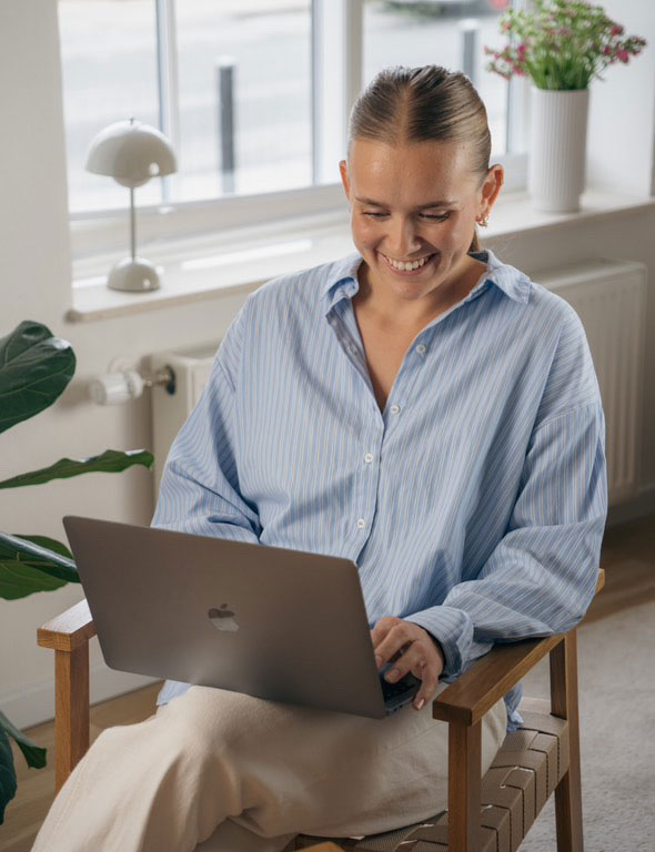 Træneren smiler, mens han kigger på den bærbare computer.